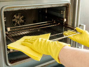 Male Hand With Gloves Cleaning Oven