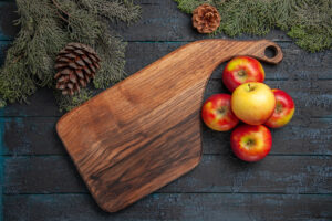 Top Close View Apple Board Five Yellow Reddish Apples Wooden Cutting Board Grey Table Tree Branches With Cones