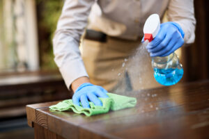 closeup waitress disinfecting tables outdoor cafe