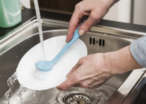 high angle woman washing plate