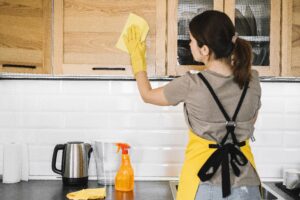 medium shot woman cleaning kitchen