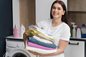 woman holding pile clean clothes